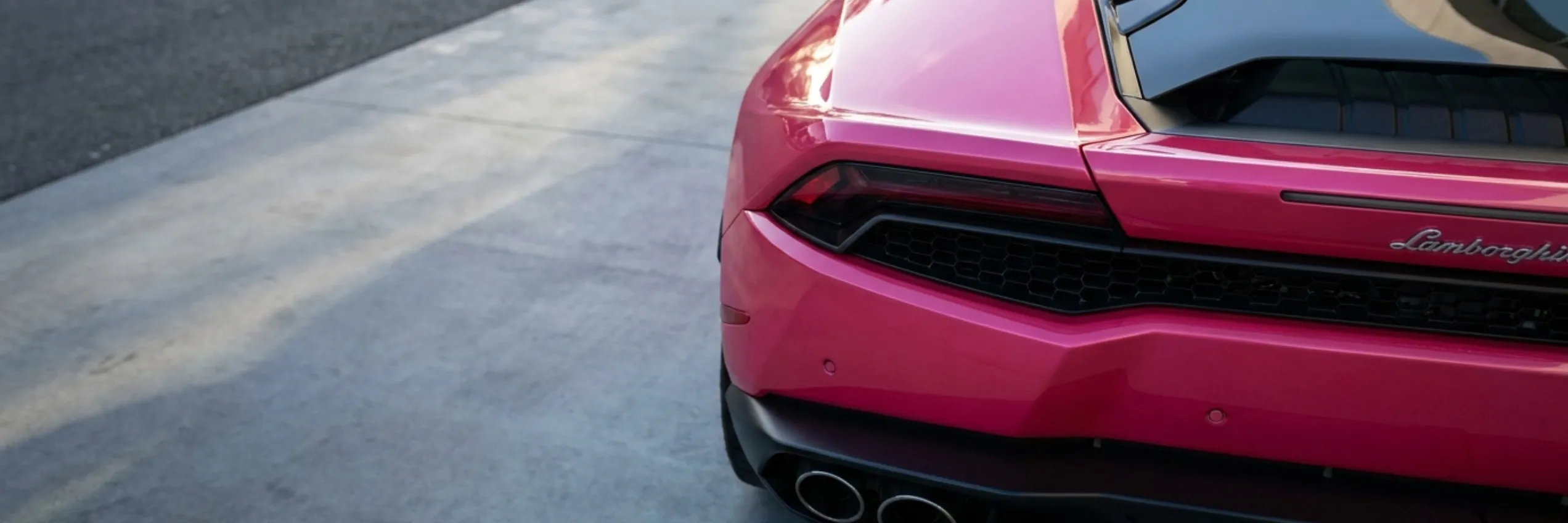 Rear of a pink Lamborghini Huracan with a glossy, freshly detailed finish
